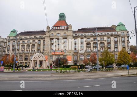 Budapest, Ungarn - 6. November 2019: Das berühmte Danubius Hotel Gellert in der ungarischen Hauptstadt. Jugendstil-Hotelgebäude mit angrenzender Straße und Straße. Bewölktes Tag, horizontales Foto. Stockfoto