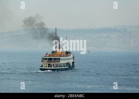 Die Fähre der Istanbul City Ferry Lines fährt bei nebligen Wetter. Rauch steigt aus seinem Kamin. Stockfoto