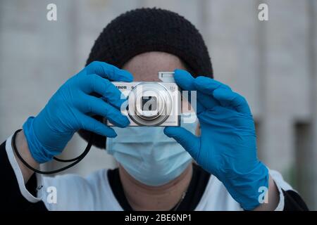 Eine ultra-orthodoxe Jüdin, die wegen der COVID-19-Coronavirus-Pandemie Schutzmaske und Latexhandschuhe trägt, fotografiert mit einer kleinen Taschenkamera in Mea Shearim, das als Ultra-orthodoxe Nachbarschaft in Jerusalem bezeichnet wird. Israel Stockfoto