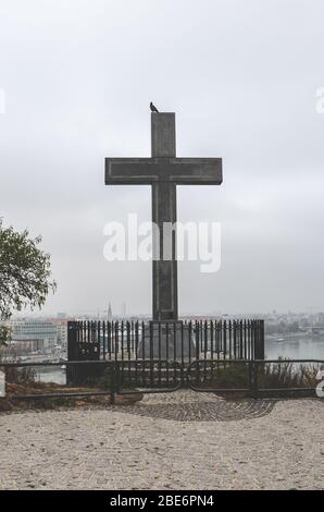 Budapest, Ungarn - 6. November 2019: Kreuzdenkmal auf dem Gellert-Hügel in der ungarischen Hauptstadt. Donau und die Altstadt im Hintergrund. Bewölktes Wetter, wolkiger Himmel. Christliches, religiöses Konzept. Stockfoto