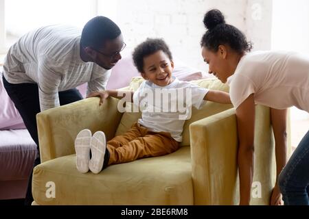 Glücklich african american paar bewegen Sessel mit wenig Sohn. Stockfoto