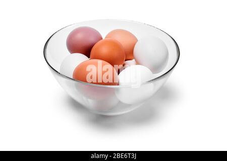 Eier verschiedener Farbtöne von Weiß bis Braun in einer Glasküssel, isoliert auf weißem Grund Stockfoto