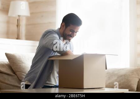 Glücklich männlichen Kunden mit schnellen Lieferservice zufrieden, Unboxing Kauf. Stockfoto