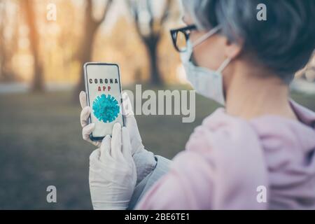 Ältere Frau mit Covid-19 Telefon-App Stockfoto