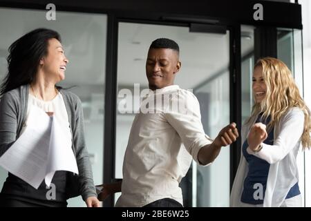 Aufgeregt verschiedene Mitarbeiter tanzen im Büro feiern Stockfoto