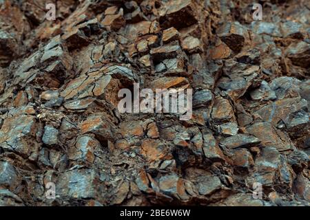 Natürliche Basaltsteinwand mit Rissen und Spalten. Gesteinsstruktur. Graphit Steinwand.Steinhintergrund. Fotografie mit natürlichem Tageslicht. Struktur Stockfoto