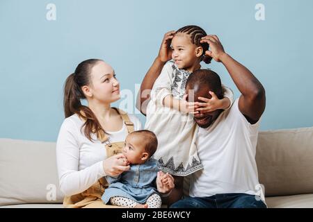 Familie posiert für ein Foto, Tochter verhält sich falsch, Spaß haben. Stockfoto