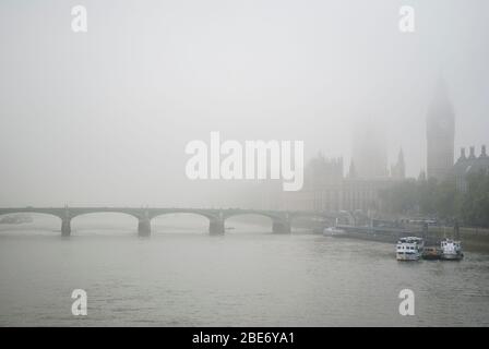 Neblige Schwarz-Weiß-Ansicht von Big Ben und den Houses of Parliament mit Westminster Bridge über die Themse in London, Großbritannien Stockfoto