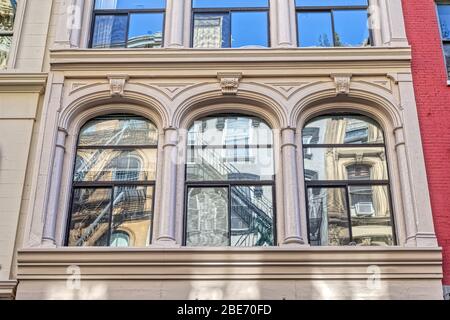 Reflexionen der Brandentweichen in den alten Steinfassadenfenstern in New York Stockfoto