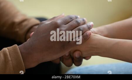 Nahaufnahme afroamerikanischen Mann Hände halten aufgeregt depressive Frau. Stockfoto