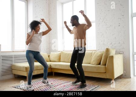 Junge glücklich afroamerikanischen Paar tanzen im Wohnzimmer. Stockfoto