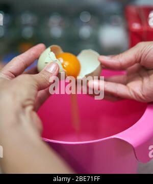 Die Hände der Frau trennen Eigelb von Weiß Stockfoto