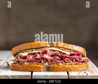 Schinken und schweizer Sandwich auf Holzfläche mit Leinenhintergrund Stockfoto