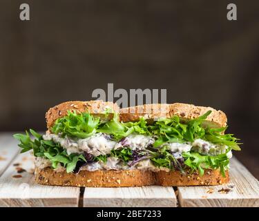 Thunfisch und Salat auf Holzfläche mit Leinenhintergrund Stockfoto