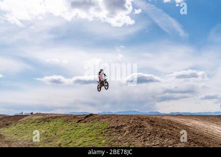 Dacono, CO/ USA- 29. März 2020 Motocross-Fahrer fahren um die Strecke und schlagen Sprünge und Berms in Colorado's Front Range Stockfoto