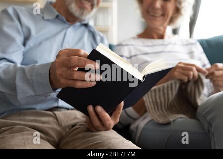 Glücklich älteren Mann Buch lesen, während Frau Stricken Stockfoto