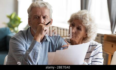 Unglücklich ältere Paar Dokumente lesen, überprüfen inländische Rechnungen Stockfoto