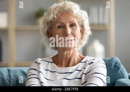 Kopf Schuss Porträt schöne reife Frau auf Couch sitzen Stockfoto