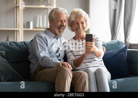 Aufgeregt reifen paar Spaß mit Telefon zusammen Stockfoto