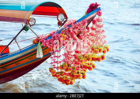 Den traditionellen thailändischen Longtail Boot mit Blumengirlande close up in Chao Phraya in Bangkok. Stockfoto