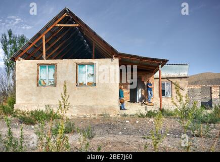 Frau mit Hut und Mensch in kariertes Hemd auf den Ruinen der alten Haus im Dorf Stockfoto