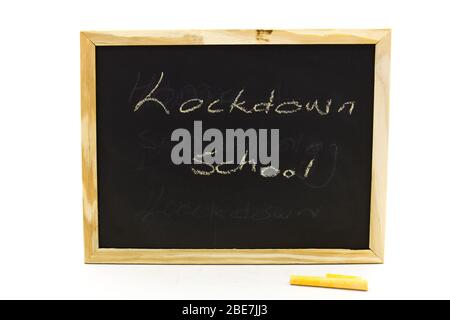 Kleine Tafel mit den Worten Home Schooling, die mit Kreide auf einem klaren Hintergrund in horizontalem Format isoliert darauf geschrieben sind Stockfoto