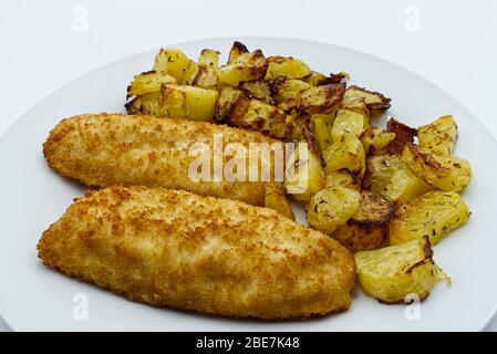 Kabeljaufilet gebacken mit Kartoffeln isoliert auf weißem Hintergrund Stockfoto