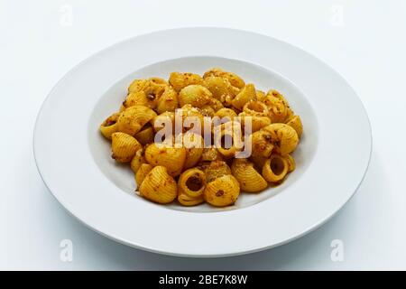 Pfeifenrigate Pasta, gefütterte Pfeifenpasta mit Bolognese-Sauce in weißer Schale. Stockfoto