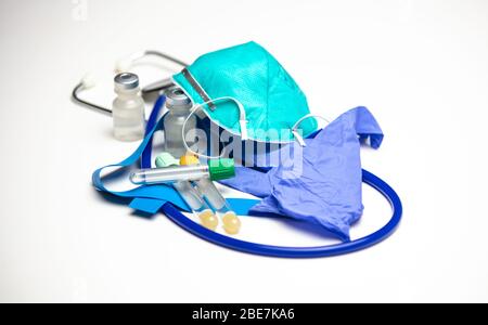 Verschiedene medizinische Verbrauchsmaterialien. Atemschutzmaske auf den Handschuhen. Leere Blutentnahmeschläuche. Stockfoto