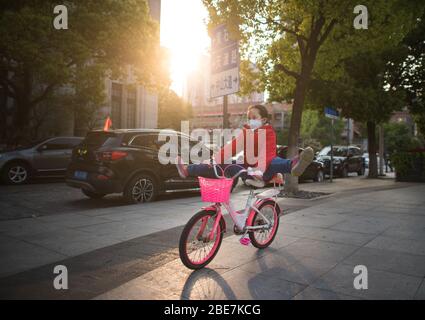 (200413) -- PEKING, 13. April 2020 (Xinhua) -- EIN Kind fährt auf einer Straße in Wuhan, der zentralen Provinz Hubei, mit dem Fahrrad, 12. April 2020. (Xinhua/Xiao Yijiu) Stockfoto