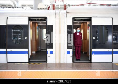 (200413) -- PEKING, 13. April 2020 (Xinhua) -- EIN Mitarbeiter wartet auf Passagiere in einem Zug am Chongqing West Railway Station im Südwesten Chinas Chongqing Gemeinde, 12. April 2020. Laut dem örtlichen Eisenbahnunternehmen wurde am Freitag eine Hochgeschwindigkeitsstrecke, die große Städte in Chinas südwestlicher Region verbindet, in Betrieb genommen. Die Strecke erstreckt sich über 1,290 km und verbindet Chengdu, Hauptstadt der Provinz Sichuan, die Gemeinde Chongqing und Guiyang, Hauptstadt der Provinz Guizhou. Eine Fahrt dauert etwa acht Stunden. Der erste Zug aus der Gemeinde Chongqing in der Schleife zog aus Chongqing Stockfoto