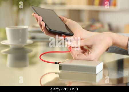 Nahaufnahme der Frau Hände stecken Powerbank auf Smartphone Akku laden Stockfoto