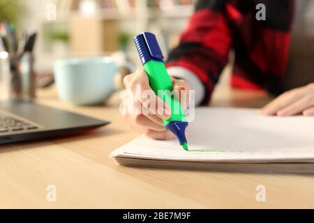 Nahaufnahme von Student Mädchen Hände mit grünen Textmarker Stift auf dem Notebook auf einem Schreibtisch zu Hause Stockfoto