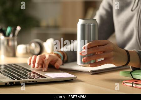 Nahaufnahme von Student Mädchen Hände halten Energie trinken kann in der Nacht auf einem Schreibtisch zu Hause studieren Stockfoto