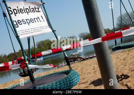 Absichtlich schief gezogenes Bild des Schildes mit deutscher Aufschrift: Spielplatz an einem Spielplatz blockiert Ausrüstung für Kinder, Konzept foto covid 19 Stockfoto