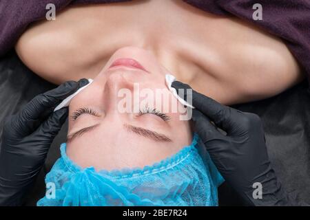 Reinigen Sie mit Hilfe von Wattestäbchen das Gesicht der Kosmetik im Spa Stockfoto