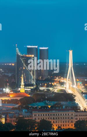 Riga, Lettland - 2. Juli 2016: Luftaufnahme von Stadtbild in Abend Nacht Leuchten aufleuchten. Schloss, Residenz des Präsidenten, Swedbank Hauptquartier, Buildi Stockfoto