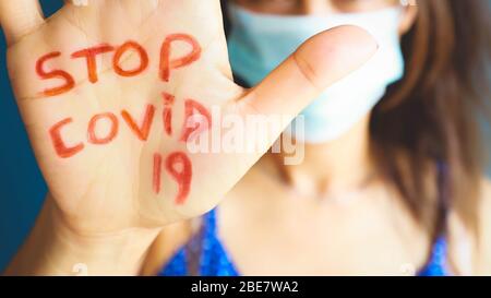Text Stopp covid-19 auf asiatische Frau Hand, Warnung vor Coronavirus, das gefährlichste Virus Stockfoto