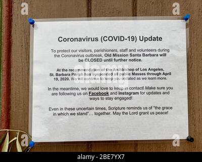 Santa Barbara, Kalifornien, USA. April 2020. Am Ostersonntag ein Schild an der verschlossenen Tür der Historischen Mission in Santa Barbara, die ihre Kirche während des Covid-19 Ausbruch geschlossen. Das Schild an der Tür lädt die Gemeindemitglieder dazu ein, sich die Dienste über soziale Medien anzusehen. Quelle: Amy Katz/ZUMA Wire/Alamy Live News Stockfoto