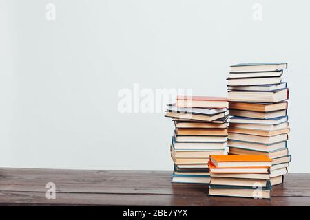 Viele Stapel von Lehrbüchern, die in der Bibliothek auf weißem Hintergrund gelehrt werden Stockfoto