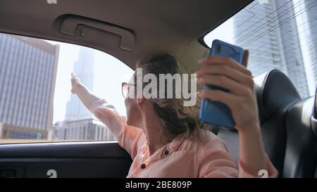 Das Mädchen sendet live aus einem Auto mit einem Telefon aus Dubai. Stockfoto