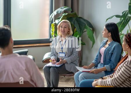 Rehabilitation. Gruppe junger Menschen, die ein Gespräch mit Psychiater Stockfoto