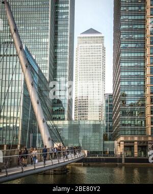 LONDON - OKTOBER 2018: Menschen überqueren die Brücke nach Canary Wharf, Londons globalem Banken- und Finanzdienstleistungsviertel Stockfoto