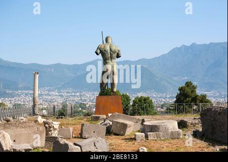 Die Bronze-Kriegerskulptur von Igor Mitoraj blickt während einer temporären Ausstellung in der antiken Stadt Pompeji in Italien auf die Hügel Kampaniens Stockfoto