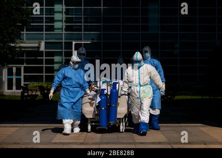 (200413) -- WUHAN, 13. April 2020 (Xinhua) -- Medizinische Mitarbeiter überstellen COVID-19-Patienten in schwerem und kritischem Zustand auf die Intensivstation (ICU) auf dem Zhongfaxincheng Campus des Tongji Krankenhauses, das der Huazhong Universität für Wissenschaft und Technologie in Wuhan, der zentralen Provinz Hubei, angeschlossen ist, 12. April 2020. Der Patient ist ein medizinischer Mitarbeiter, der an vorderster Front im Kampf gegen COVID-19 infiziert wurde. Die Stationen im 9. Stock von Gebäude C auf dem Zhongfaxincheng Campus des Tongji Krankenhauses, das der Huazhong Universität für Wissenschaft und Technologie angeschlossen ist, die von übernommen wurde Stockfoto