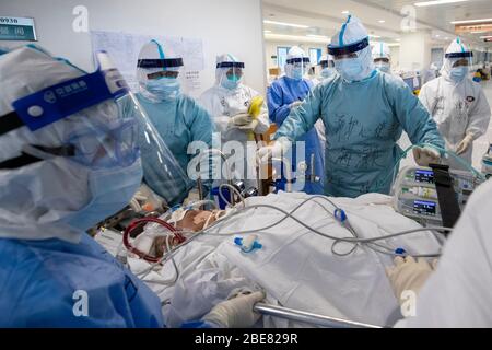 (200413) -- WUHAN, 13. April 2020 (Xinhua) -- Medizinische Mitarbeiter verlegen einen COVID-19-Patienten in schwerem und kritischem Zustand, der sich einer extrakorporalen Membranoxygenierung (ECMO) unterzogen hat, auf die Intensivstation (ICU) auf dem Zhongfaxincheng-Campus des Tongji-Krankenhauses, das der Huazhong Universität für Wissenschaft und Technologie in Wuhan, Zentralchina, angeschlossen ist, 12. April 2020. Die Stationen im 9. Stock von Gebäude C auf dem Zhongfaxincheng Campus des Tongji Krankenhauses, das der Huazhong Universität für Wissenschaft und Technologie angeschlossen ist, die von medizinischen Teams von Peking Union Medi übernommen wurde Stockfoto