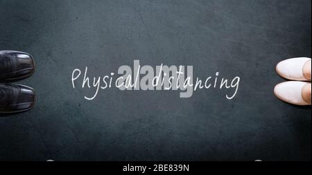 Physische Distanzierung. Zwei Personen halten sich für soziale Distanzierung voneinander getrennt, wodurch der physische Abstand zwischen den Menschen vergrößert wird, um eine Ausbreitung zu vermeiden Stockfoto