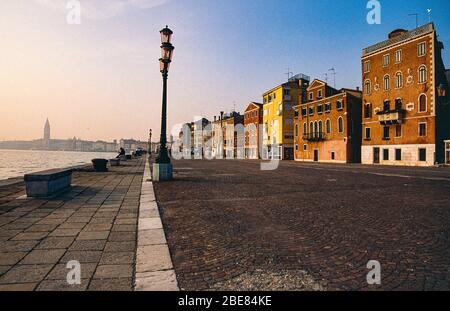 Ruhige Aussicht entlang der Riva dei Sette Martiri mit Hafengebäuden, verlassenen Riva und entfernten Campanile di San Marco, Castello, Venedig, Italien Stockfoto