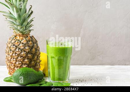 Gesunder grüner Smoothie in einem Glas aus Spinat, Ananas, Avocado, Banane und Chia-Samen. Konzept für vegane Rohgetränke. Stockfoto