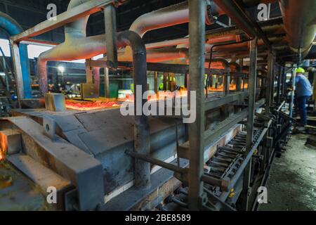 Glashütte. Glasindustrie. Brennen von Rohlingen von Glasflaschen in einem Industrieofen. Heiße Flaschenrohlinge in Flamme. Typische böhmische Arbeit. Tschechische Republik, Stockfoto